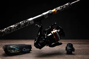 qBalzer Tactics Cat Neo harcsázó orsó Czero Ripost Catfish horgászbotra szerelve, mellette egy Czero szivacsos botvédő és egy Balzer Adrenalin Cat kapásjelző.